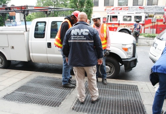 Emergency crew stand over grate where he fell